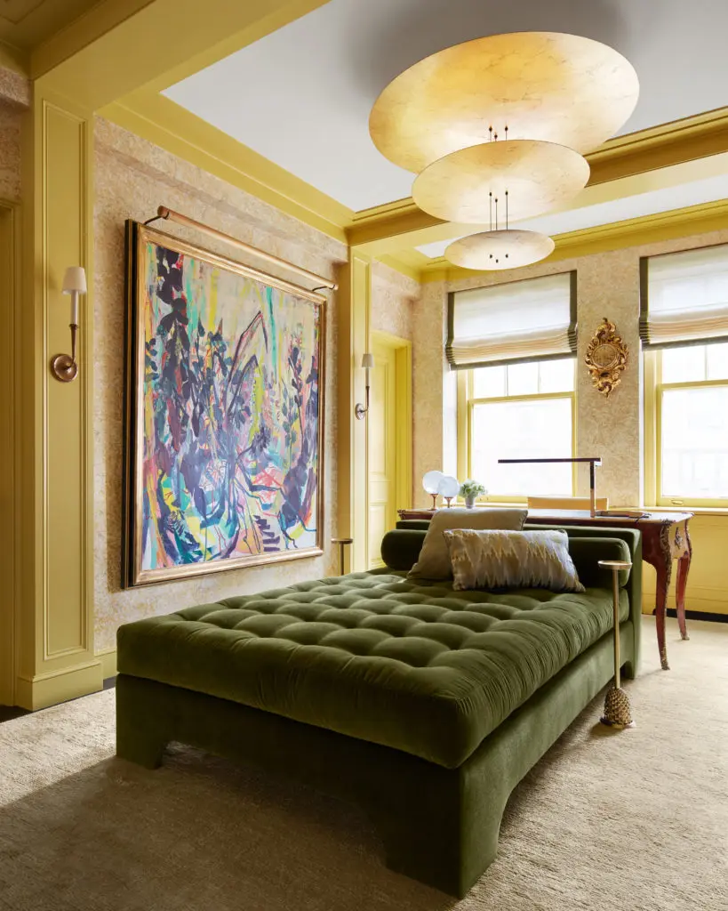  In Caleb Anderson’s New York apartment, the daybed — an upholstered mattress — is for lounging and TV watching and can double as a bed when necessary. The wallcovering has a metallic Mylar background that glows. The painting is by Allison Gildersleeve. (Photo by Stephen Kent Johnson)