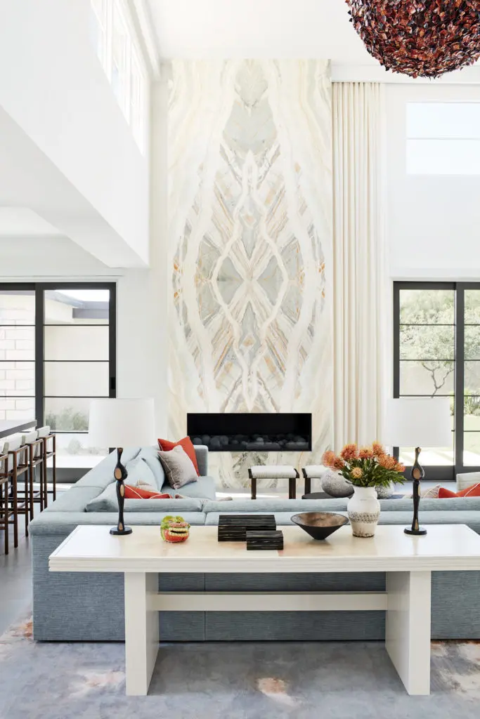In a second home in Paradise Valley, Arizona, designed by Drake/Anderson, the intimate main seating area centers on a dramatic stone-clad fireplace with adjacent bar. (Photo by Joe Schmelzer)