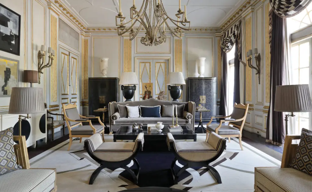  Monapesy Manor in New Delhi, originally a field of wheat with a small pond and a dozen centennial trees located in the outskirts of New Delhi, was Deniot’s first estate built from the ground up and is today a palatial splendor. Drawing its inspiration from classical antiquity, and the neoclassicism movement, the living room has paneling with gold leaf, ivory and pearl gray. A pair of cabinets are clad with black mother-of-pearl, stool in Pierre Frey velvet, and chandelier is from 1stDibs. The rug is in the style of André Arbus typical of the French 1940s, custom designed by Jean-Louis Deniot. (Photo by Stephan Julliard)