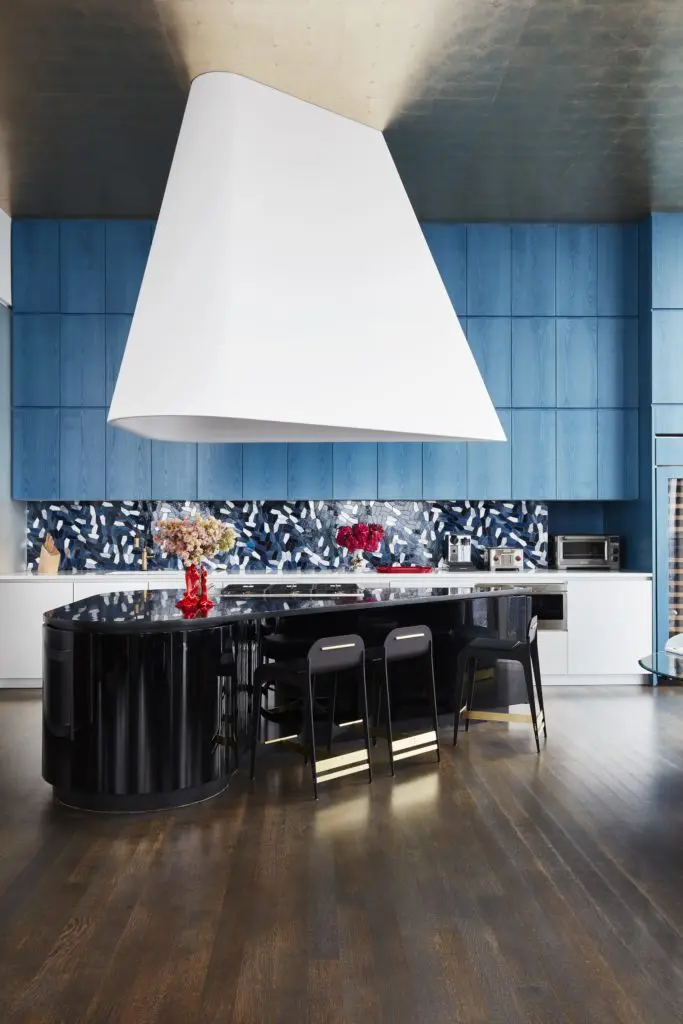 Designed by Richard Mishaan, an open kitchen in an apartment in Tribeca’s Herzog & de Meuron tower has a monumental hood by Anish Kapoor. (Photo by Thomas Loof)