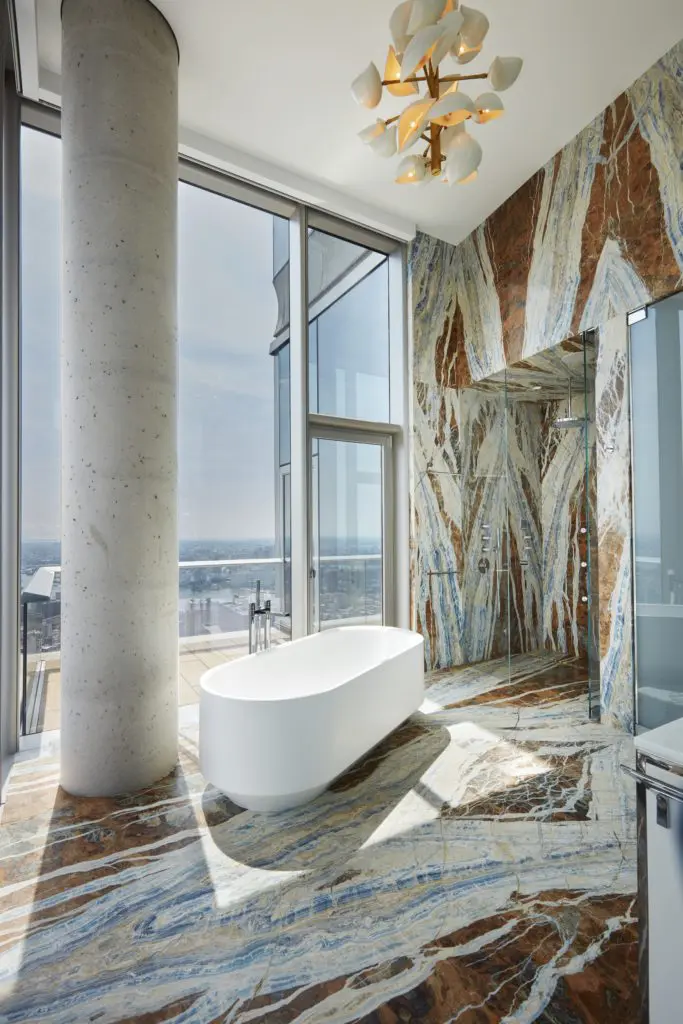 In an apartment in Tribeca’s Herzog & De Meuron tower, book-matched marble on the walls and floors of a primary bath (Photo by Thomas Loof)