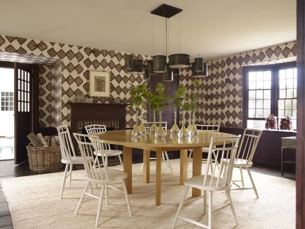 In an 18th-century New England saltbox cottage designed by Stephen Sills,  handwoven diamond ikat fabric in the dining room is complemented by an etching by Henri de Toulouse-Lautrec, makes a contemporary statement but harkens back to the 18th century. (Photo by William Waldron)