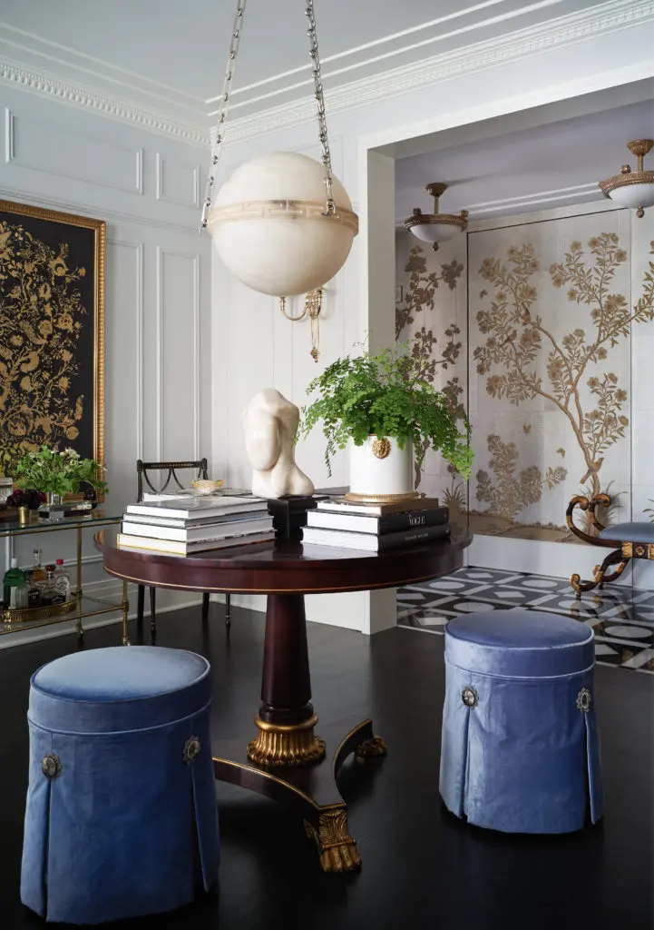 In a Deco-era Palmolive Building condo in Chicago, designed by Summer Thornton, skirted periwinkle velvet stools sit like proper little ladies, providing a foil to the strong round table. (Photo by Björn Wallander)
