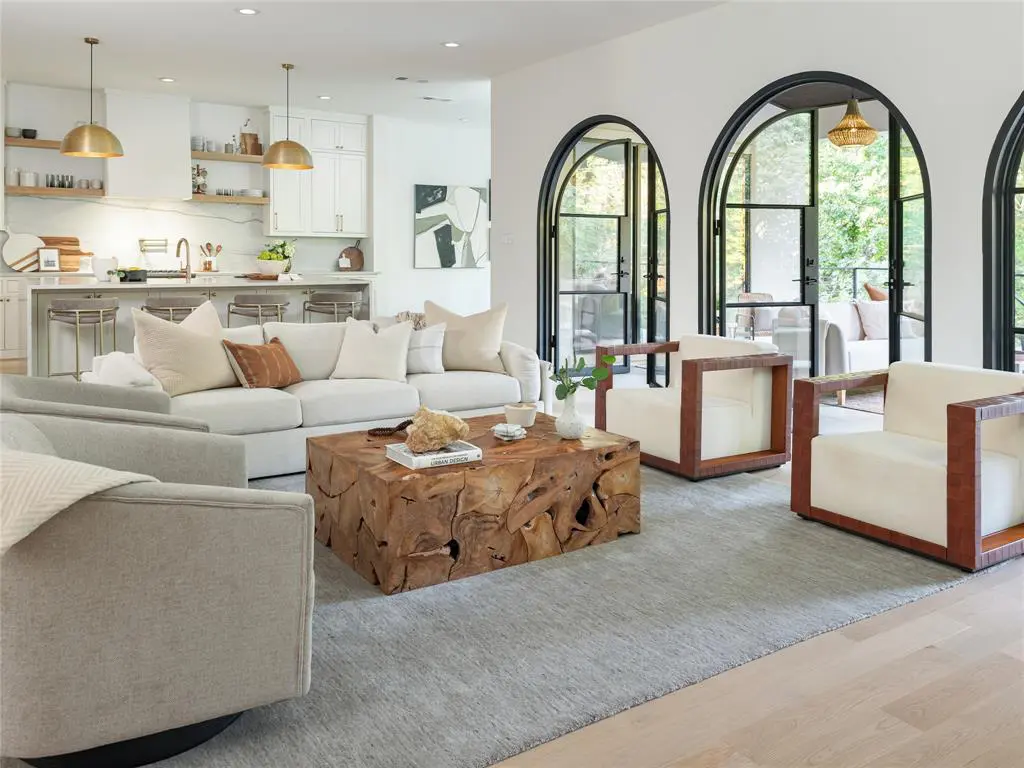 Three impressive arched steel doors open to a striking covered patio. 