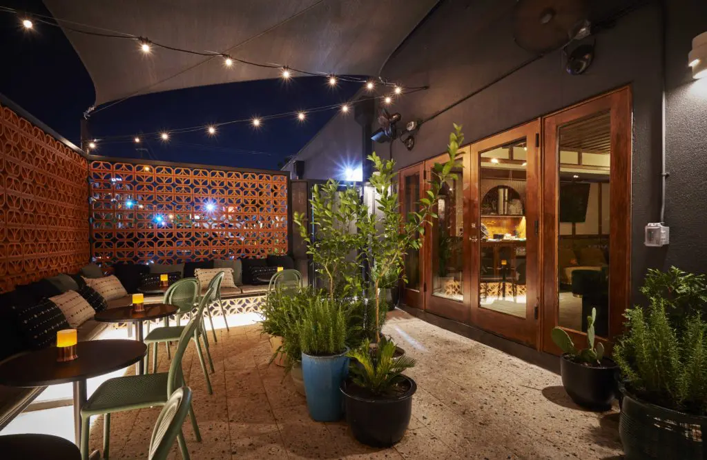 At the Clifton Club a pocket patio adjoins an intimate, light-filled garden room with the club’s most coveted seating. (Photo by Jonathan Zizzo)