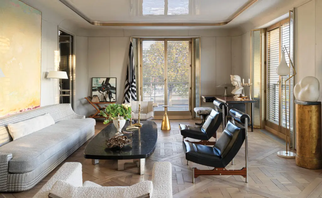 In Jean-Louis Deniot's new offices on the Quai 'Orsay coffee table by
Ado Chale, custom-designed Jean-Louis Deniot sofa upholstered in Edmond Petit and Pierre Frey; cushion in Boussac with Houlès piping. Pair of floor lamps by Jacques Adnet, lampshade Anne Sokolsky, abstract painting “Campagne” by Françoise Brunet. Empire porcelain rafraichisseur, pair of seventeenth-century Spanish bronze candlesticks, 1930s bronze sculpture Plateau au Trésor. Pair of Piet Hein Eek armchairs, side table by Hilquily from Yves Gastou; drinks table by Cesare Lacca. Flag artwork Sol LeWitt. Pair of fireside
Pagoda chairs by Steiner Gilbert; floor lamp by Sciolari. Art déco golden column.