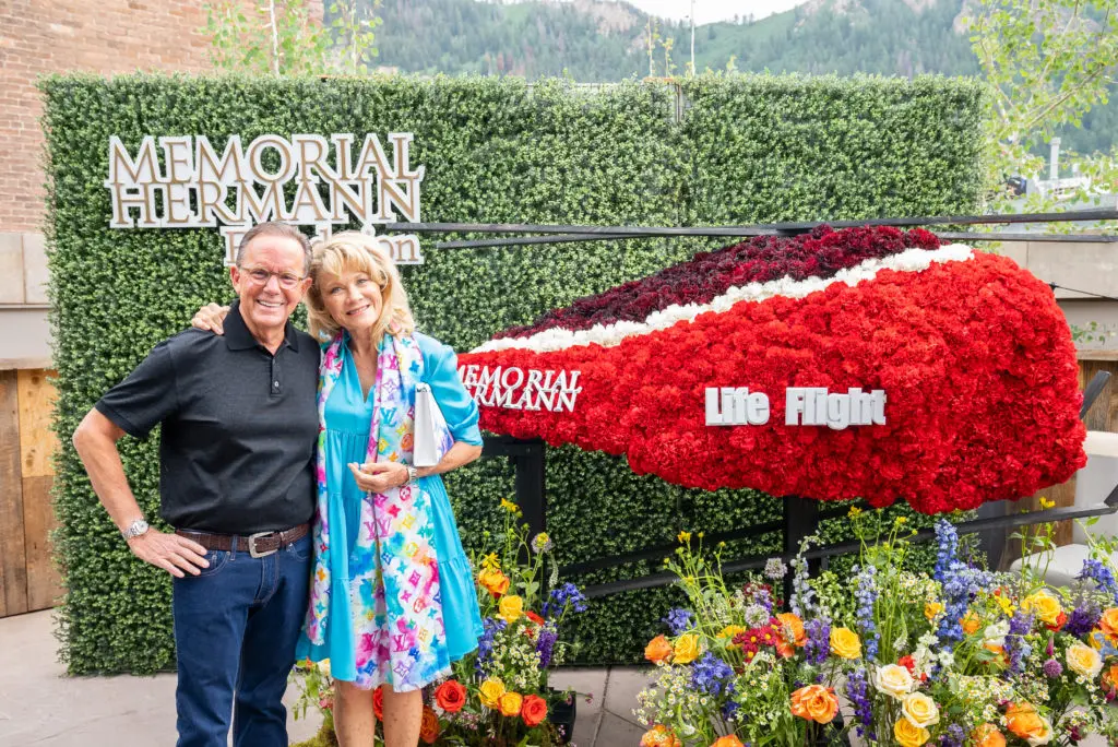 Jerry & Lisa Simon with the dazzling red floral Life Flight helicopter. (Photo by Daniel Ortiz)