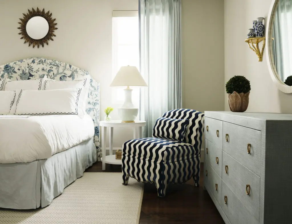 The master bedroom headboard is upholstered in Lee Jofa, Aerin Sayre in Blue. The striped club chair is upholstered in Schumacher The Wave in Navy. (Photo by Jack Thompson)
