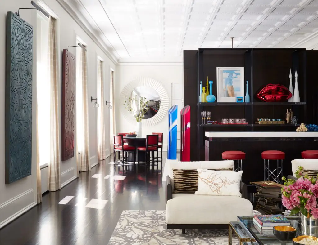 Hung between the windows of an art lover's Soho loft designed by Richard Mishaan, rare carvings by Keith Haring are just a few of the standout pieces in the owner’s collection. A freestanding bar separates the kitchen from the rest of the living area. (Photo by Max Kim-Bee)