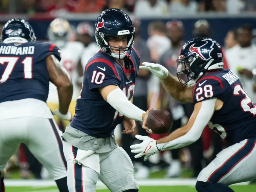 Texans quarterback Davis Mills hands off the football to veteran running back Rex Burkhead. (Photo by F. Carter Smith)
