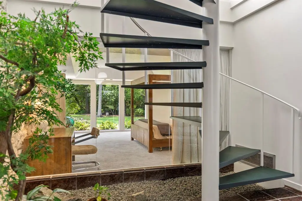 The spiral staircase encased in an atrium overlooks the primary bedroom at 503 Timber Terrace Road. (Photo by Nan Studios)
