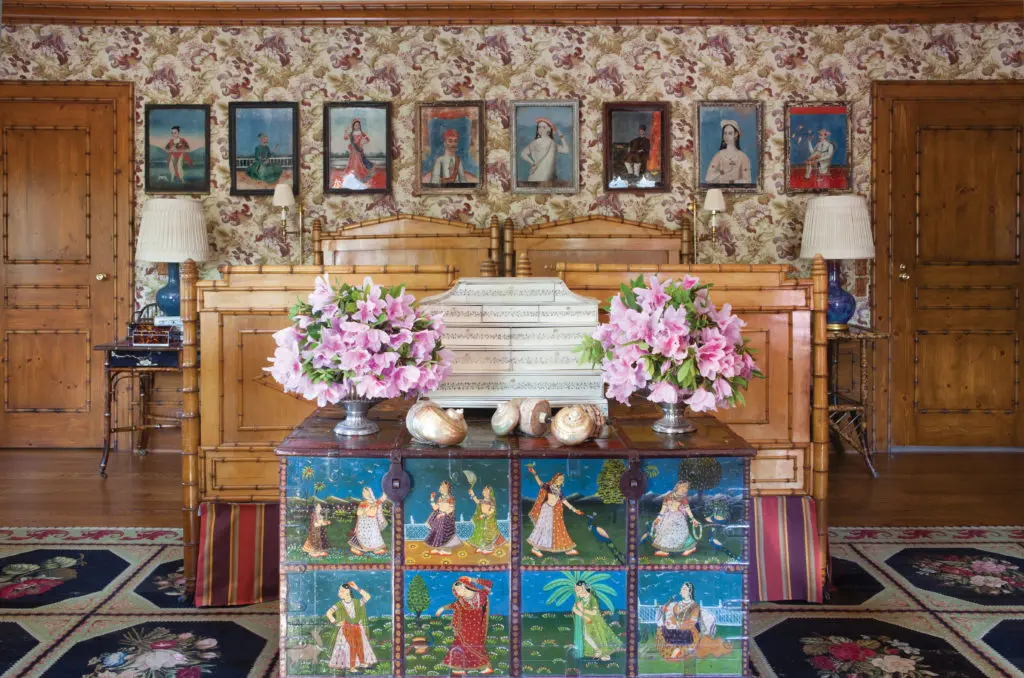 A "bamboo" guest room reflects Ann Getty's enduring love for traditional Indian decorative arts and Anglo-Indian craftsmanship. Front and center is a fine example of the art of Mughal India, a 19th-century painted padouk wood chest that depicts sari-clad women and peacocks in palace gardens. Walls are covered with Rosemount cotton by Marvic, London. (Photography by Lisa Romerein)