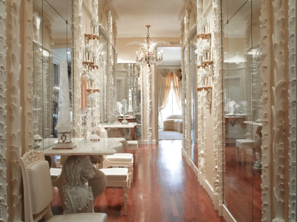 Ann Getty worked with San Francisco antiques dealer Terry Gross to plan the elaborate mirrored hallway of Gross's Nob Hill apartment as a subtle homage to the Hall of Mirrors, the dazzling feature of the Château de Versailles. It's also a nod to California interior designer Frances Elkins, another Francophile, who first introduced the chic plaster palmier columns and torchières of 1920s Paris designer Serge Roche to her clients. These hallway moldings were created in white plaster from original Régence models by Féau & Cie. (Photography by Lisa Romerein)