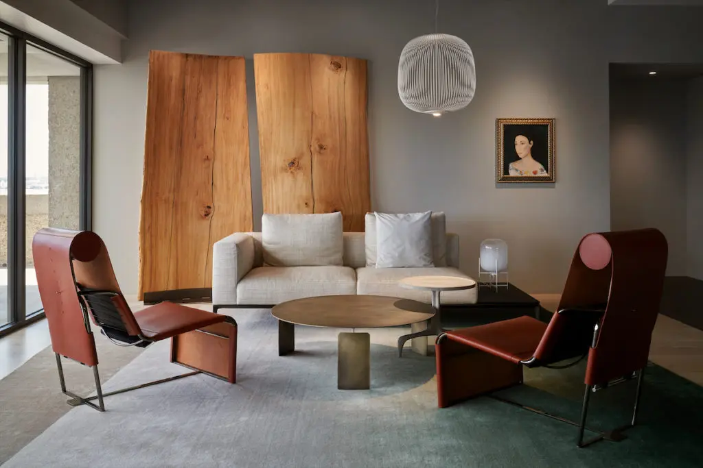 The living room’s wood sculpture is made from salvaged pine from Diane and Ray Krueger’s tree farm, with an iron base created by George Sacaris Studio, Houston. CC-Tapis custom rug, Mingardo coffee tables, and Walter Knoll Atelier chairs and settee, all from Shop showroom, Houston. Foscarini pendant. Portrait from the clients’ collection. (Photo by Pär Bengtsson)
