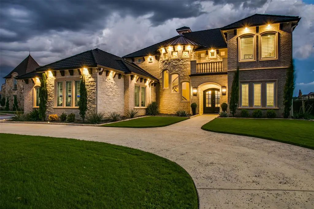 6025 Lakeside's Mediterranean exterior lit up by night.
