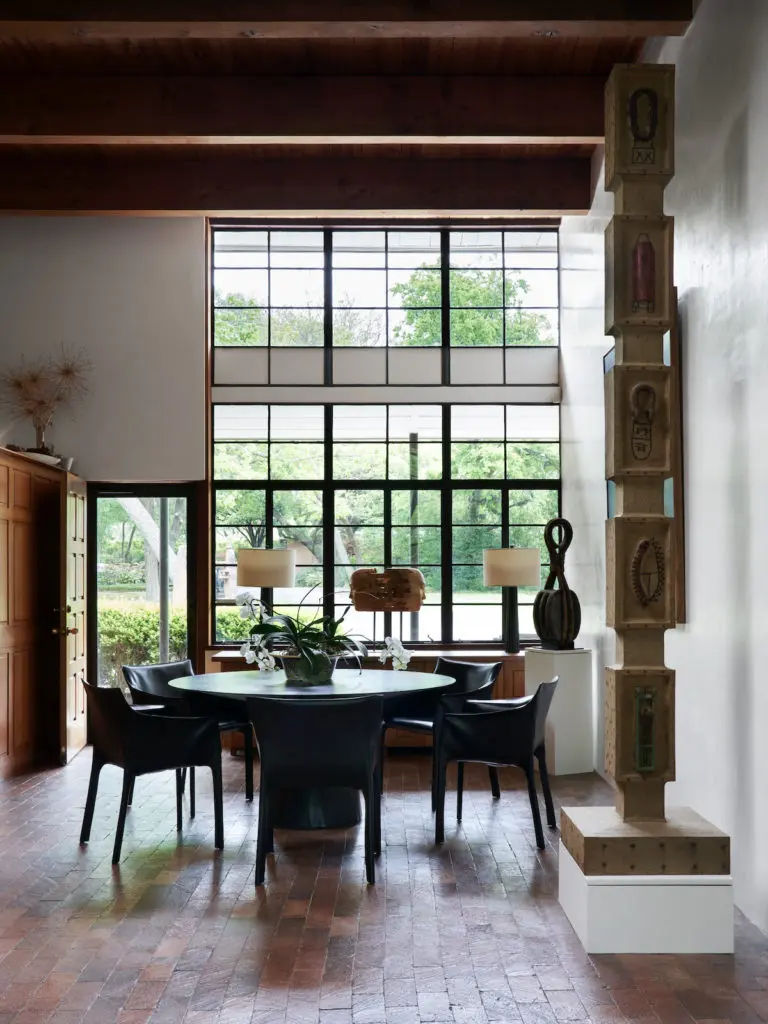 In the dining area are vintage Matteo Grassi chairs and a tall column by self-taught Louisiana artist Clyde Connell. On a pedestal, an object salvaged from a sailing ship, circa 1880, from Joel Cooner Gallery. (Photo by Pär Bengtsson / art direction by Michelle Aviña)