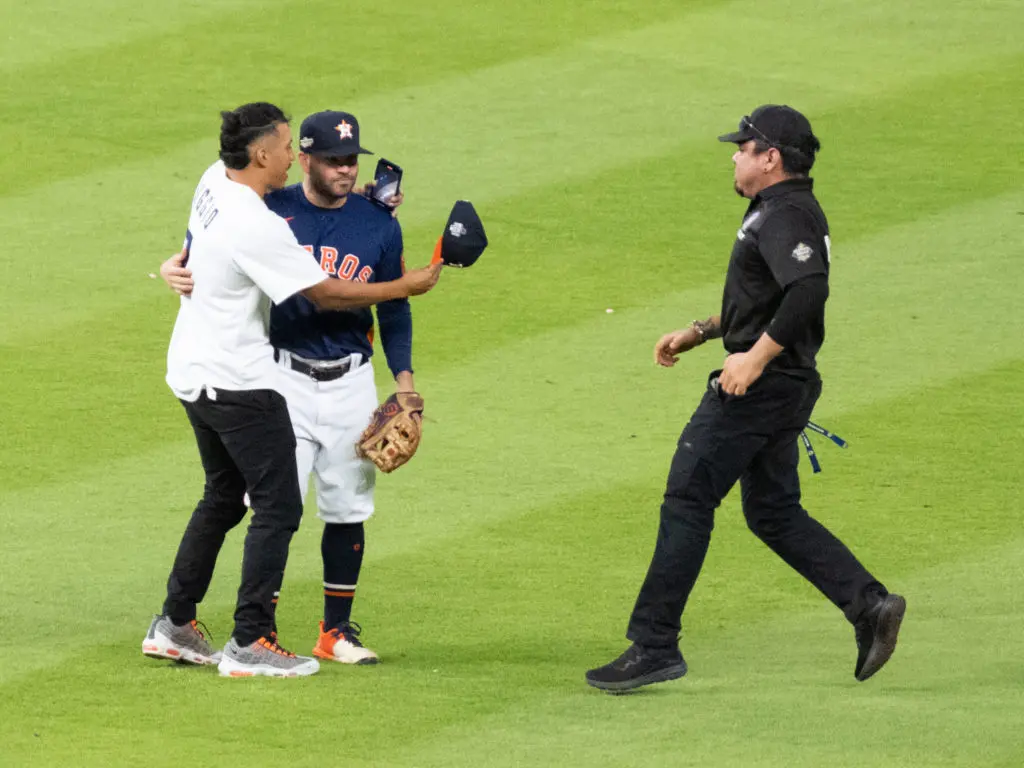 A fan ran onto the field and wrapped Astros star Jose Altuve up in a hug. (Photo by F. Carter Smith)