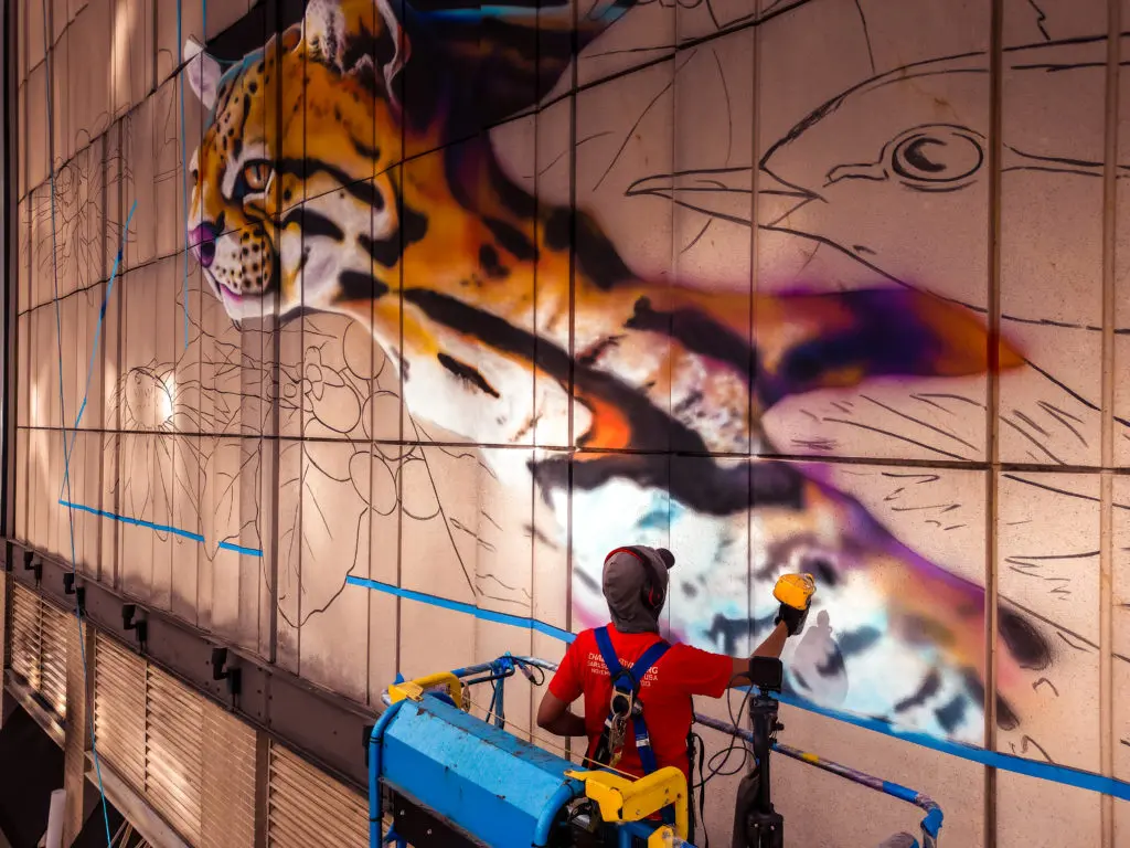 Carlos Alberto paints a vibrant jungle in "Hoping for a Greener Future." (Photo by @superkant and @cyvisuals_, courtesy Street Art for Mankind)