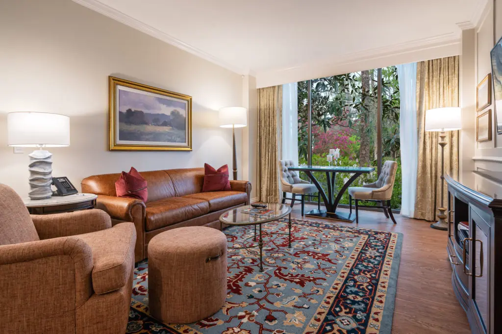 The Houstonian Hotel also feature two-bedroom suite, like this one replete with a glass topped table by the floor-to-ceiling windows that grant you a view of the verdant bayou below. (Photo by Courtesy of The Houstonian Hotel, Club and Spa)