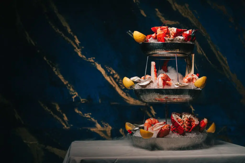 The three tiered chilled seafood tower can be served with a combo lobster, shrimp, East Coast oysters, and crab legs on ice.  Photo Raydon Creative