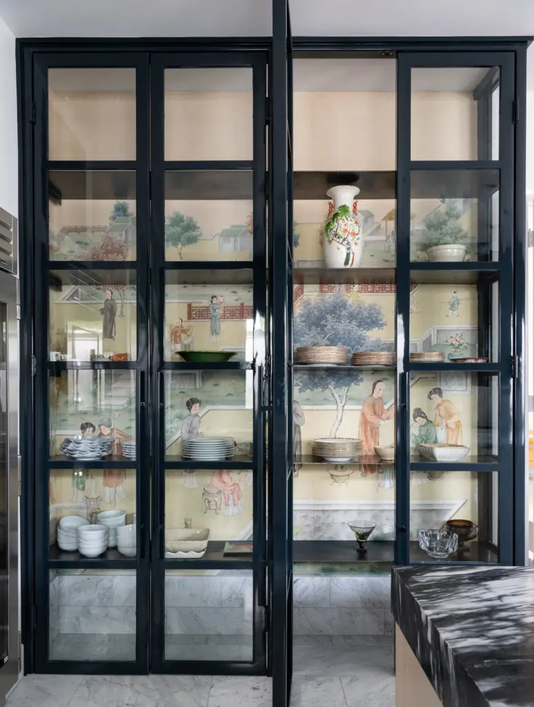The custom iron China cabinet is backed by salvaged antique Japanese wallpaper in the kitchen. Photo by Michael Hunter