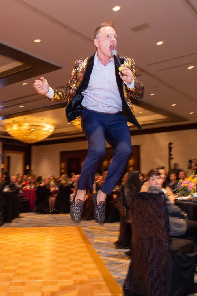 Celebrity auctioneer Johnny Bravo jumps for joy at the million dollar success of the Ronald McDonald House gala. (Photo by Jacob Power)