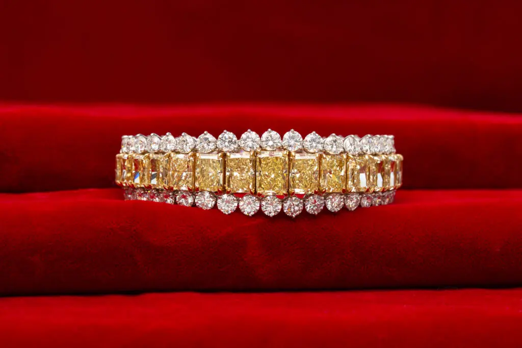 Important estate radiant-cut fancy yellow – fancy intense yellow diamond bracelet with round brilliant-cut white diamonds, 61.53 total carat weight