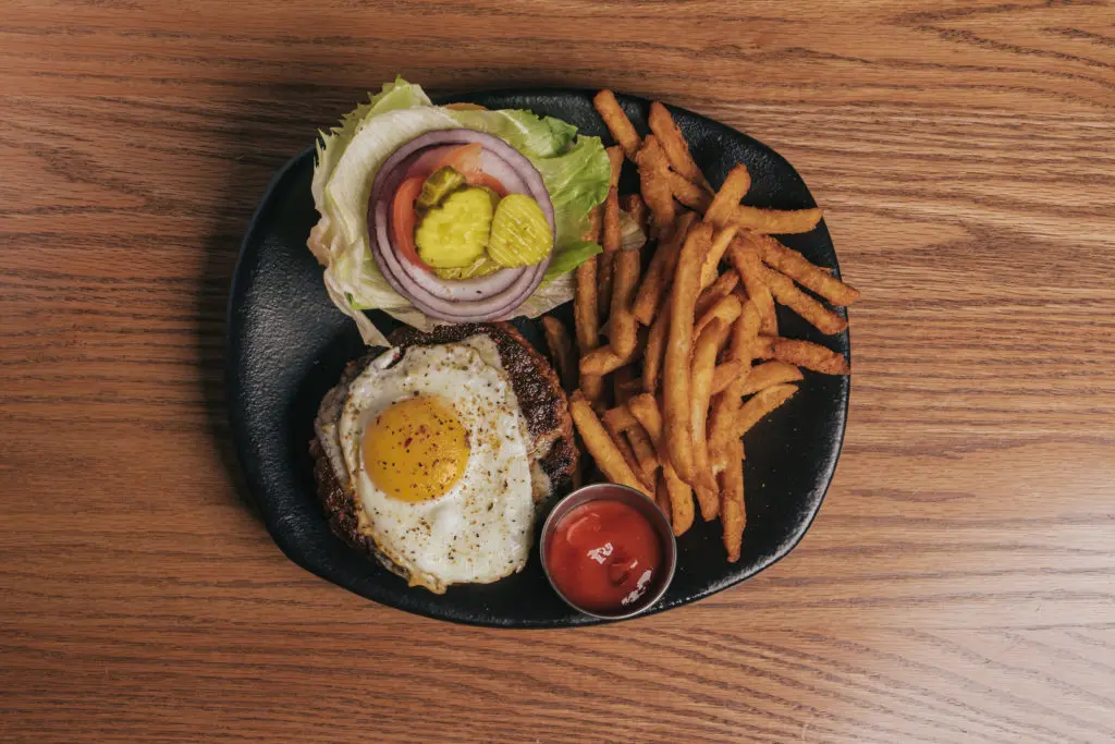 The mighty Anaya's burger at the new Houston restaurant Gatsby's Grill is made with prime beef, topped with a sunny side fried egg, lettuce, tomato, bacon, garlic aioli, and pepperjack cheese. (Photo by Raydon Creative)