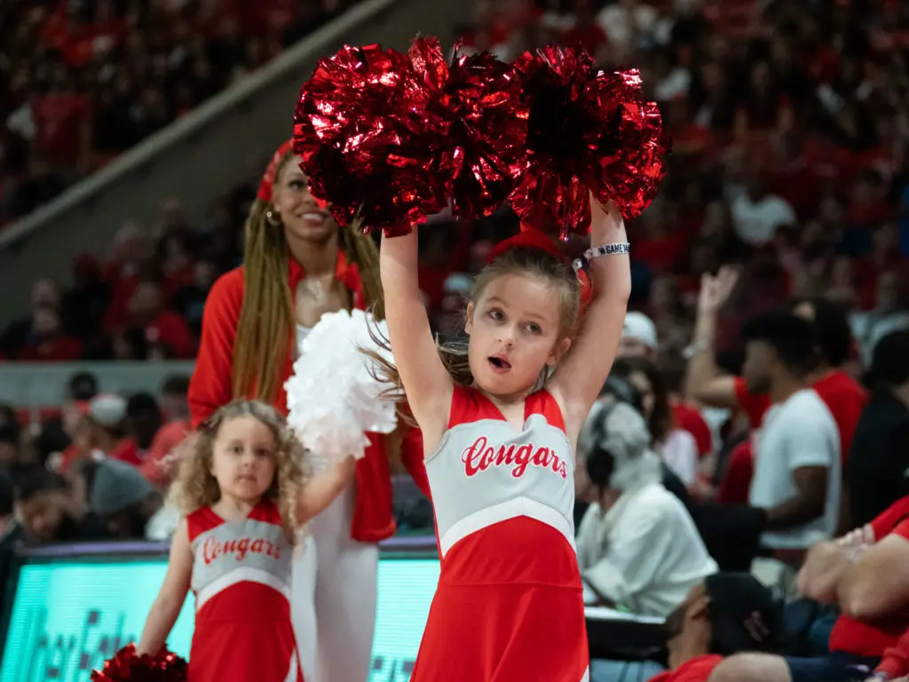 Maisy Jade Sampson (left) and friends love spending game time with the cheerleaders. (Photo by F. Carter Smith)