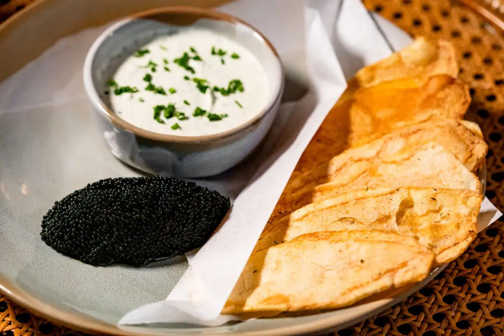 Caviar and chips served with a generous portion of farmed lumpfish roe that’s a glossy and inky black-looking dupe for the pricier osetra. (Photo by Kirsten Gilliam)