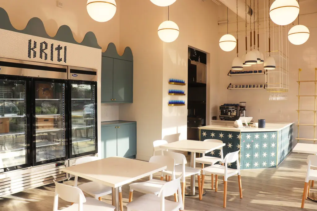 Designed by Houston-based Allie Wood Design Studio, Kriti Kitchen features modern-style dining tables and counter seating. Pops of vibrant blue cabinets and bronze globe pendant lighting give the restaurant a retro look.  (Photo by Ajna Jai)