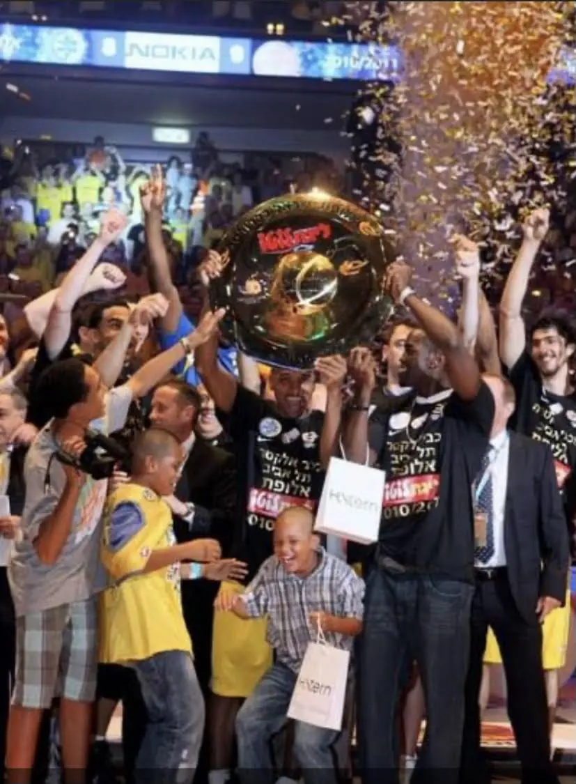 When Derrick Sharp won a championship for Maccabi Tel Aviv, his then young son Emaneul Sharp was right there. Derrick Sharp holds up the trophy as Emanuel Sharp dances with joy.