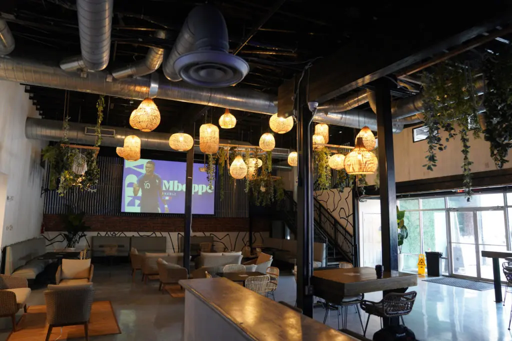 Tulum HTX is a 5,000 square foot multi-level space decorated with expansive photo murals, Aztec tiles, and rattan decor.