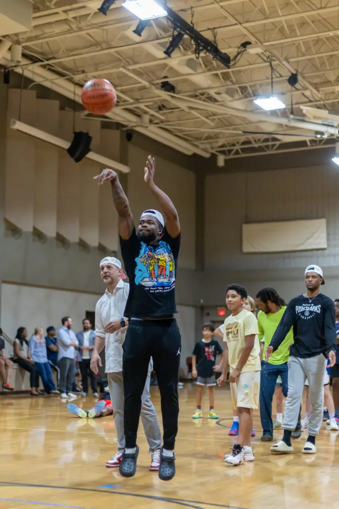 UH point guard Jamal Shead played some shooting games with the kids at the New Leaf event. (Courtesy New Leaf real estate) 