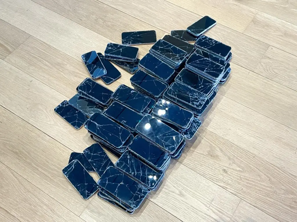 A collection of cracked iPhone screens in the ecology section of I'll Be Your Mirror. (Photo by Courtney Dabney)