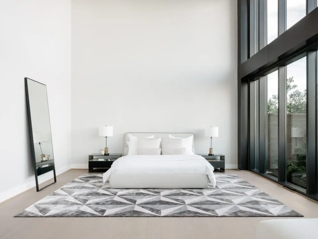 The main floor primary bedroom of the CASA Companies' condo enjoys two stories high windows facing north. (Photo by Divya Pande)