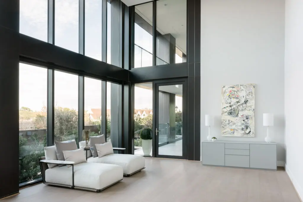 The main floor primary bedroom of the CASA Companies' condo enjoys two stories high windows facing north. (Photo by Divya Pande)