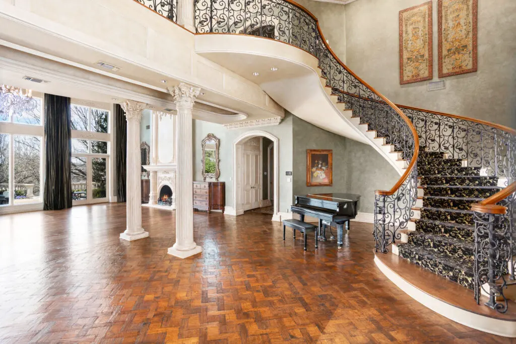 Inlaid wood flooring, grand spiral staircase and soaring 28-foot ceilings greet you at the entry.