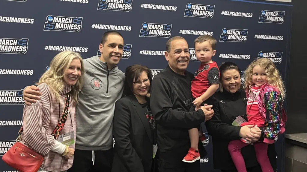 Karen Sampson (center, next to her husband Kelvin Sampson) gathers the whole Sampson family together for what she dubs "The annual Sweet 16 family photo" in a back hallway at Legacy Arena after the comeback win over Auburn. (Photo by Chris Baldwin)
