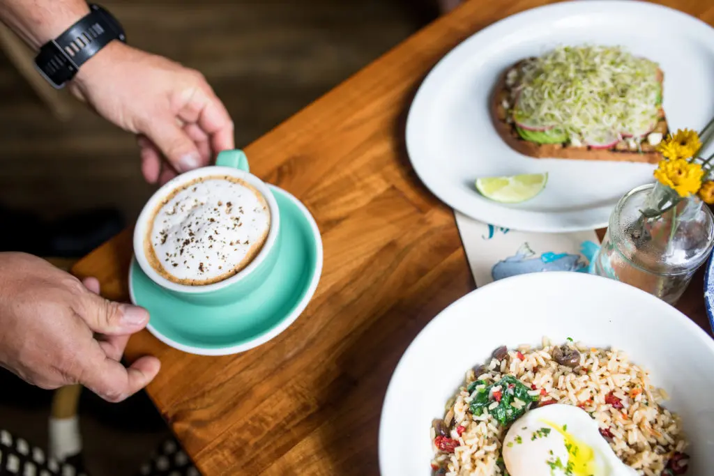 An array of breakfast goodies — Salmon Hoppin John, a  Latte, and Avocado Toast — is available at Eloise Nichols.