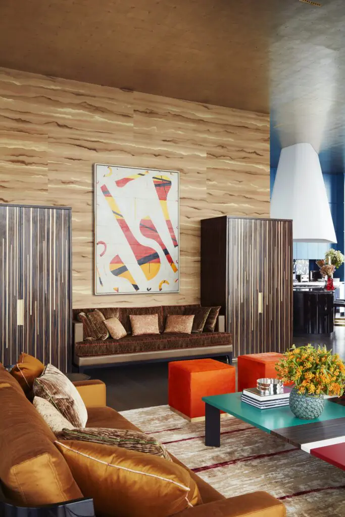 A cocktail table by India Mahdavi
plays off the colors in a work by Caio Fonseca hung on a wall covered in hand-painted Fromental grasscloth. (Photo by Thomas Loof) 