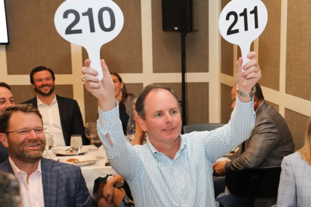 Double-handed bidding at the Houston Classical Charter School Foundational Dinner (Photo by Priscilla Dickson)