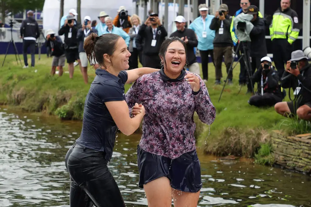 Lilia Vu (right) and her trainer gets out after jumping in the water to celebrate winning the Chevron Championship. (Photo by Stacy Revere/Getty Images)