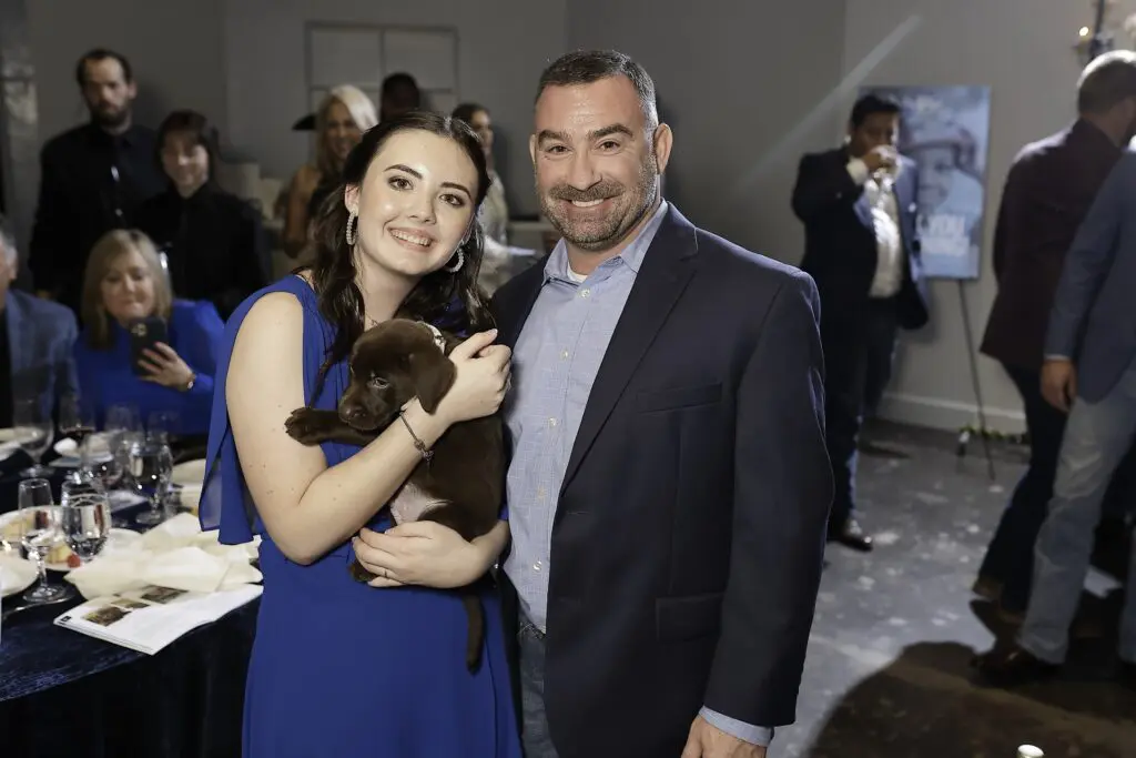 Lucky guests take home one of the puppies from the live auction at the Sky High for Kids banquet evening at The Revaire. (Photo by Quy Tran)
