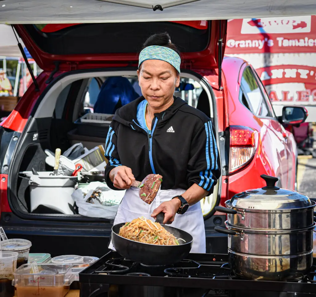 A vendor prepares food at The Woodlands Farmer’s Market at Grogan’s Mill.  Photo by Jessica T. Payne
