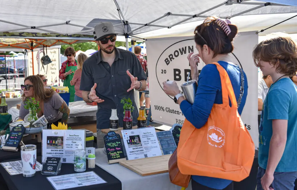 Market-goers browse vendor booths while shopping at The Woodlands Farmer’s Market at Grogan’s Mill. Photo by Jessica T. Payne