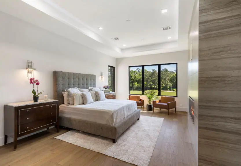 The primary bedroom, complete with fireplace,  overlooks the golf course at 114 S. Timber Top in Grogan's Mill.  (Photo by Engage Realty Media)