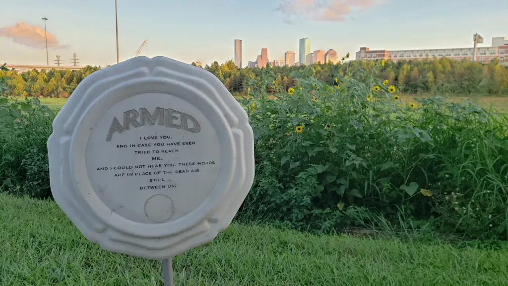 Lovie Olivia's "ARMED," a public art series created in 2019. With the downtown Houston skyline and sunflowers in the background, the message reads, "I love you, and in case you have ever tried to reach me, and I could not hear you, these words are in place of the dead air still between us." (Courtesy the artist) 