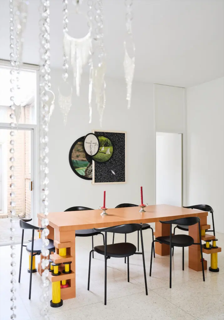 In the dining room, a Memphis table by Ettore Sottsass and Hans Wegner chairs. Photo-based artwork by Todd Gray. Kayode Ojo chandelier sculpture. (Photo by Jack Thompson)