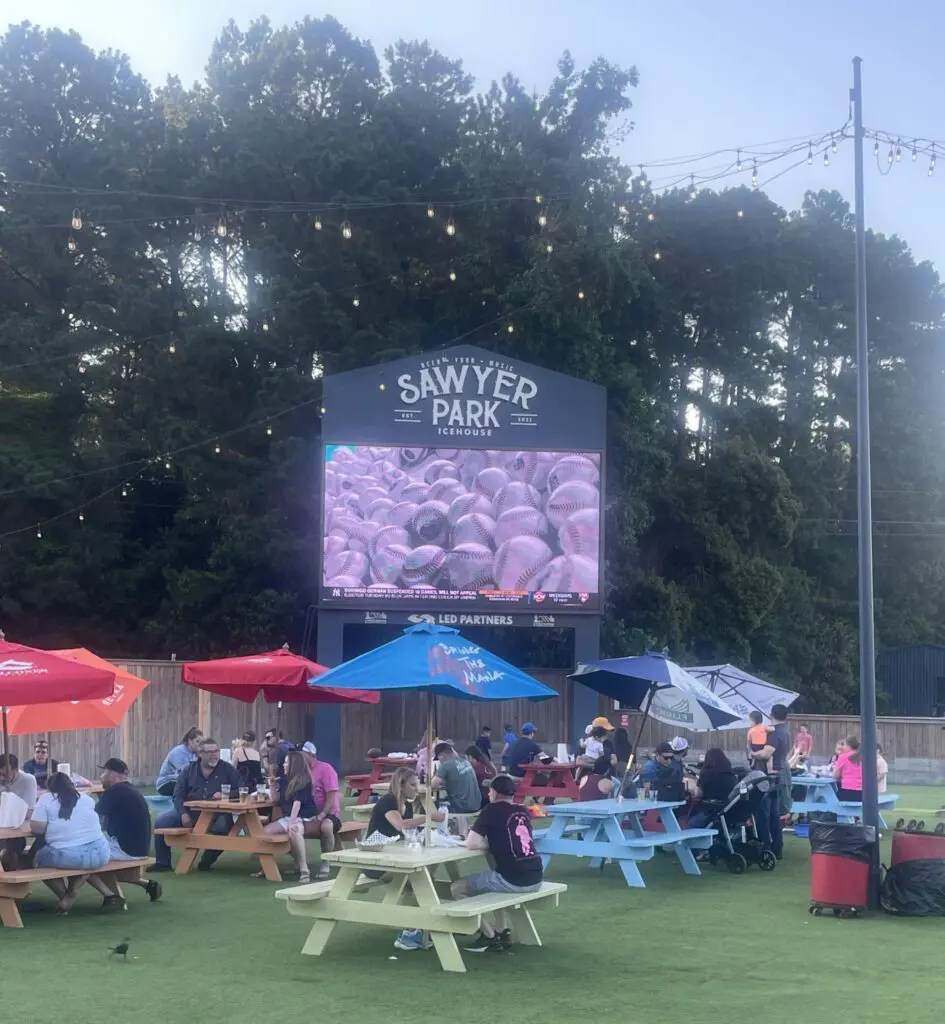 Sawyer Park's big outdoor screen is always tuned to a major sporting event. (Photo by Laura Landsbaum)
